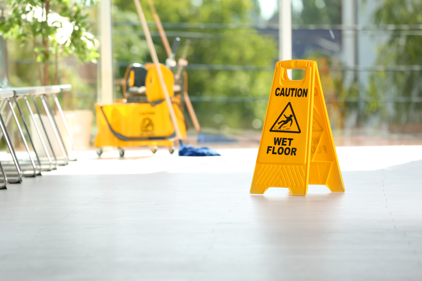 a "caution, wet floor" sign warning of potential danger of slips and falls.