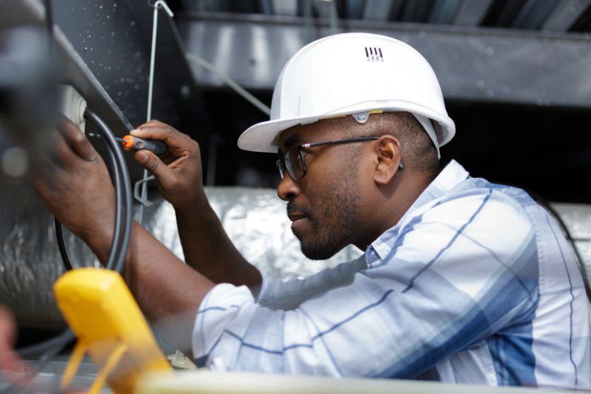the image shows an electrician wearing a hard hat, representing the article about worker's compensation and employment. 